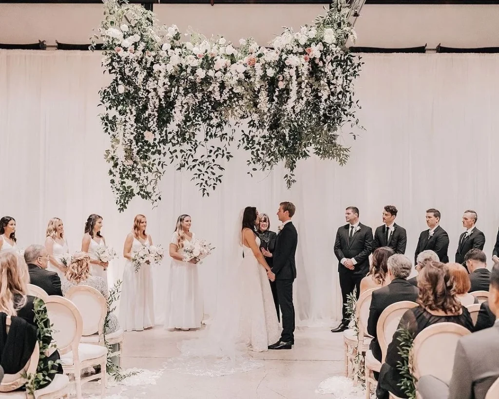 "Our favorite flower hanging installation was at this ceremony. Our flower team designed a 10 ft long by 12 ft